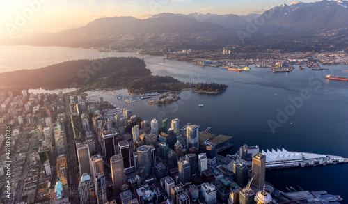 Aerial View from Airplane of Vancouver Downtown, British Columbia, Canada, during a bright winter sunset. Modern Urban City on the West Pacific Coast. Landmark of Stanley Park.