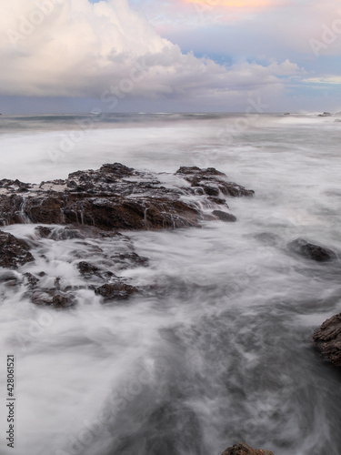 Fototapeta Naklejka Na Ścianę i Meble -  High tide water flowing into rocky coastline.