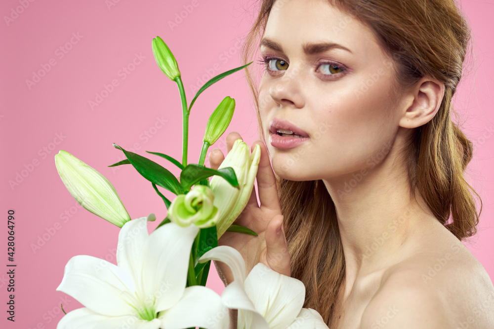 Portrait of woman with white flowers beautiful face pink background naked shoulders Portrait of woman with white flowers beautiful face pink background naked shoulders
