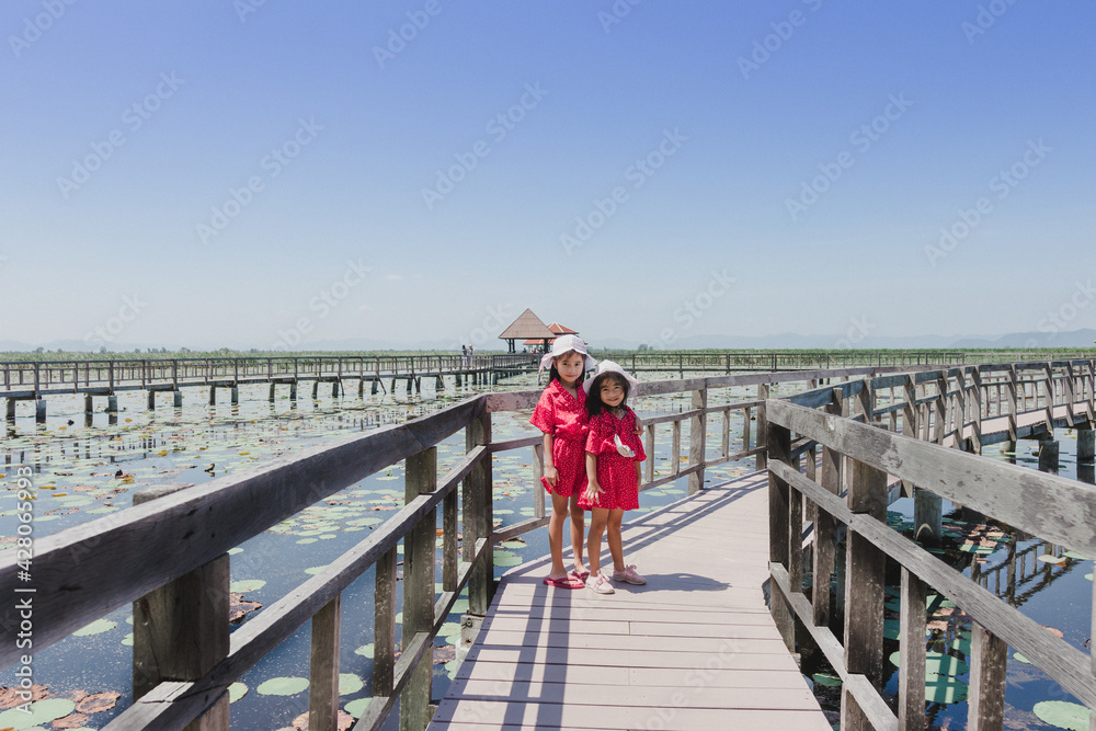 Two cute little girls standing in bridge