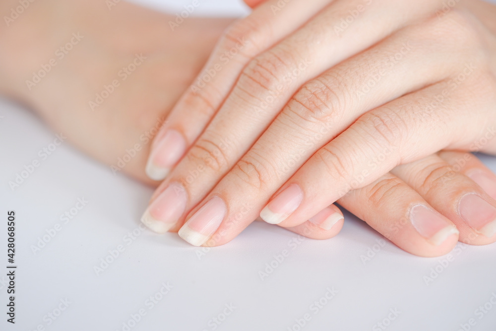 Closeup of beautiful hands and fingernails of woman on white background, Concept of health care of the fingernail.