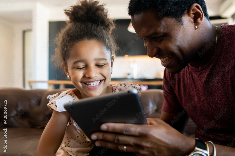 Father and daughter using digital tablet at home. Father and daughter using digital tablet at home.
