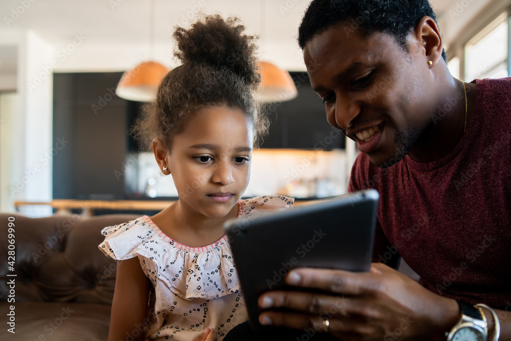 Father and daughter using digital tablet at home. Father and daughter using digital tablet at home.