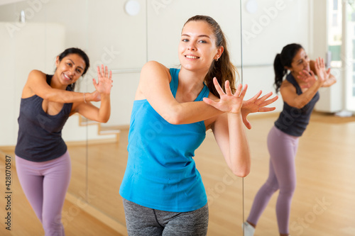 Canvas Print Positive slim athletic women dancing aerobics at lesson in the dance class