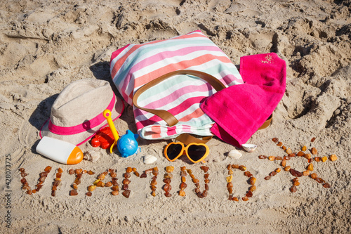 Inscription vitamin D, accessories for relax and childrens playing on sand at beach. Prevention of vitamin D deficiency. Healthy lifestyle