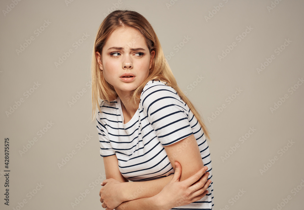 Portrait of woman on beige background gesturing with hands cropped view of striped t-shirt