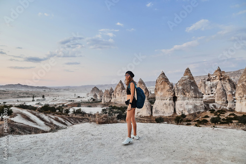 Beautiful tourist woman putting her arms up and enjoing view of Love valley in Goreme village.