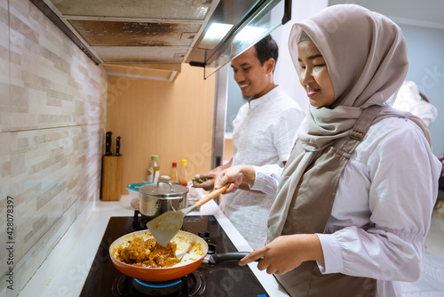 happy muslim couple cooking together in the kitchen. man and woman preparing for dinner