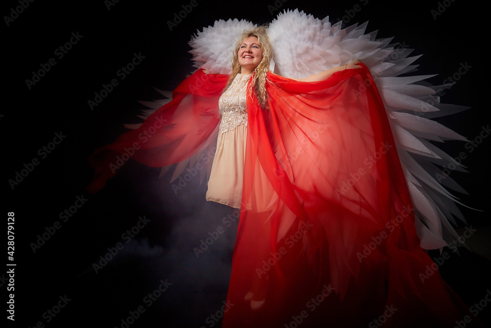 A beautiful blonde girl with curly hair and white wings looks like an nice angel