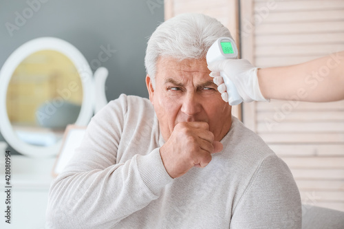 Doctor measuring temperatur...