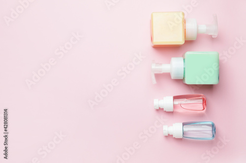 Bottles with cosmetics products on color background