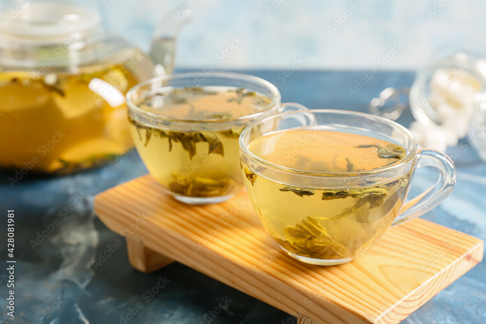 Stand with cups of green tea on color background Stand with cups of green tea on color background