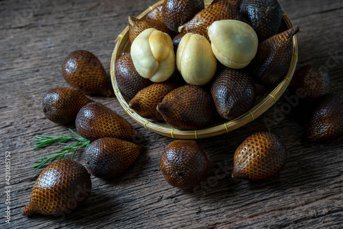 Fresh Waive fruit in Bamboo basket on wooden table, Fresh Salak or Snake Fruit tropical fruit on a wooden table.