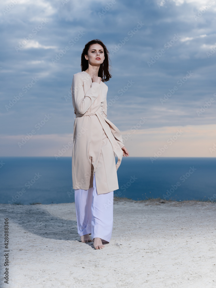 woman in light clothes by the ocean and blue sky in the background woman in light clothes by the ocean and blue sky in the background