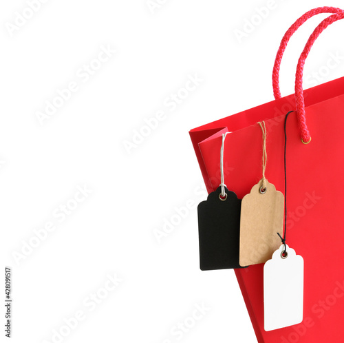 Price tags with rope hanging out of the red shopping bag isolated on white background