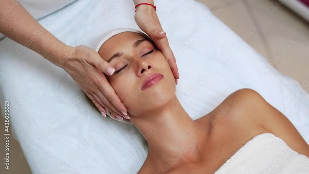 Face massage at spa salon. Doctor hands. Pretty female patient. Beauty treatment. Healthy skin procedure. Young woman head. Light background. Scrub rejuvenation. Facial dermatology mask. Detox therapy
