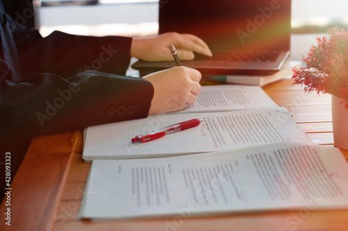 working hands on paperwork with laptop photo