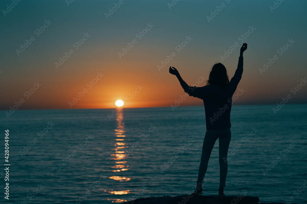 woman gesturing with her hands and sunset sea landscape beach