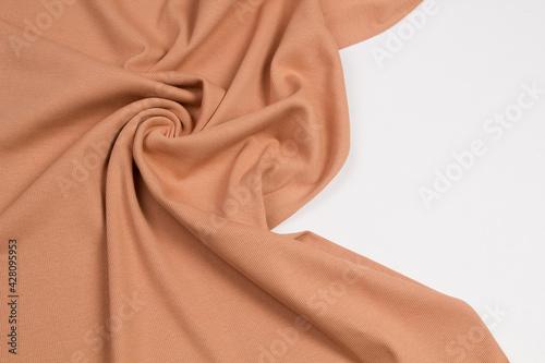Beige fabrics folded top view on a white background. Beige textile 