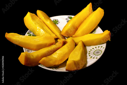Mango slices in a plate in black background