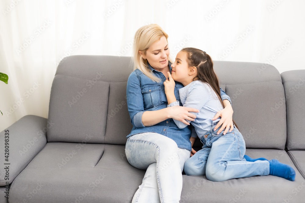 Mother smiling with her daughter at home Mother smiling with her daughter at home