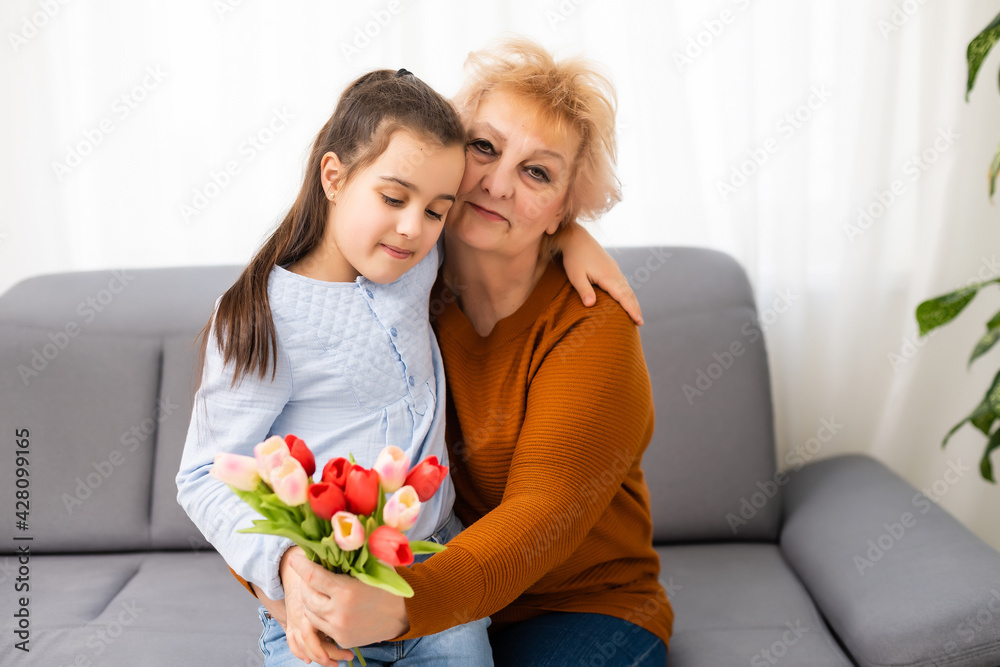 Little girl visiting her ill grandmother giving flowers Little girl visiting her ill grandmother giving flowers