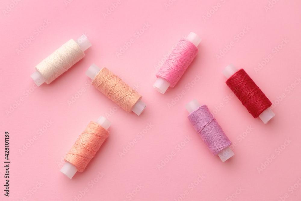 Set of threads spools on pink background Set of threads spools on pink background