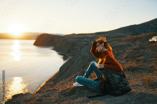 woman tourist sitting on the ground admiring nature landscape fresh air