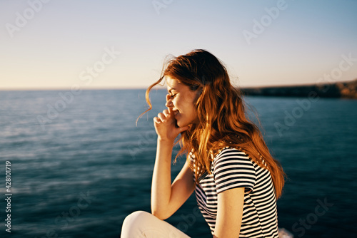 woman in t-shirt and in white trousers portrait sea sunset