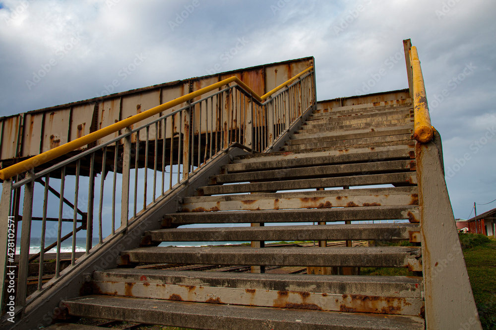 Obraz premium Rusty Steel Pedestrian Bridge over Railway Line