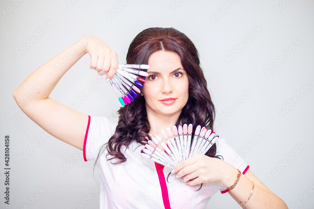 Young woman manicurist posing with nail samples Young woman manicurist posing with nail samples