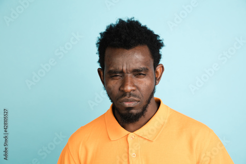 African man's portrait isolated over blue studio background with copyspace © master1305