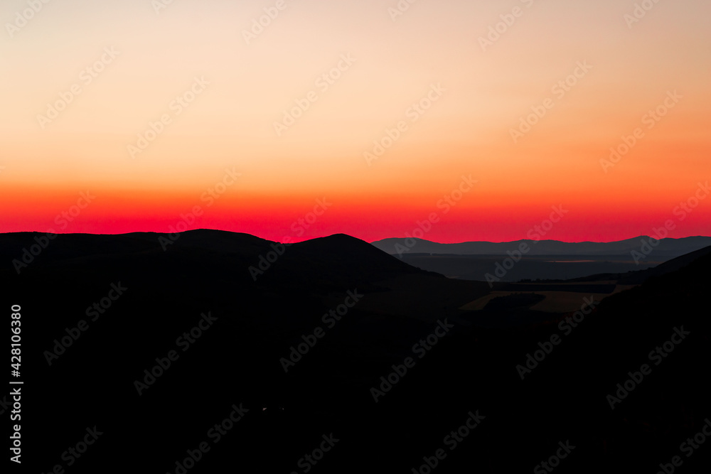 Red sunset with mountain silhouette. Scenery with mointains in sunset.