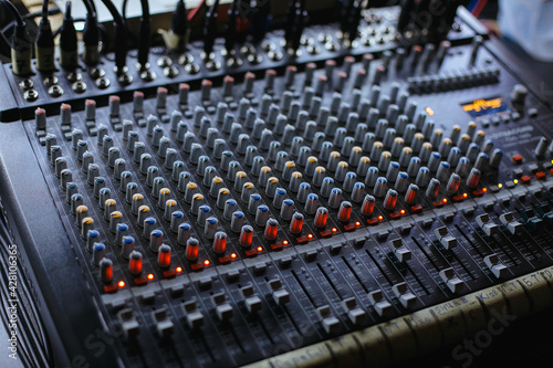 Professional audio studio sound mixer console board panel with recording , faders and adjusting knobs,TV equipment.