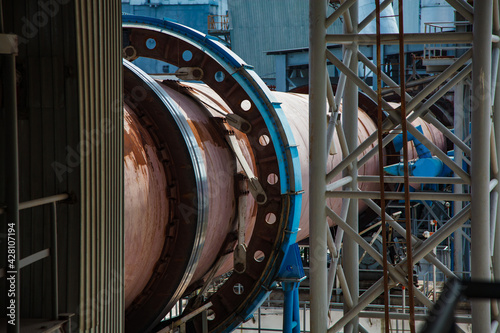 Close up of rotary clinker kiln. Rusted tube and blue gear. Standardcement plant, Shymkent, Kazakhstan