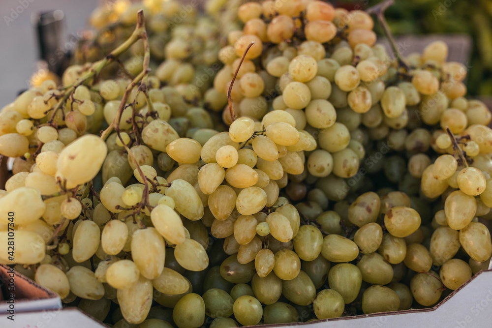 Fresh fruit brunch green grapes in paper boxes at grocery store, local products Fresh fruit brunch green grapes in paper boxes at grocery store, local products
