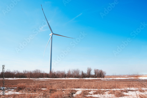 Wind generator in steppe against blue sky, environmentally friendly electricity, wind power plant.