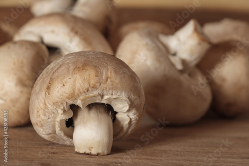 Nahuaufnahme von Pilzen: Weiße Champignons (Zuchtchampignon - Lat.: Agaricus bisporus) auf einem Holz / Brettchen photo