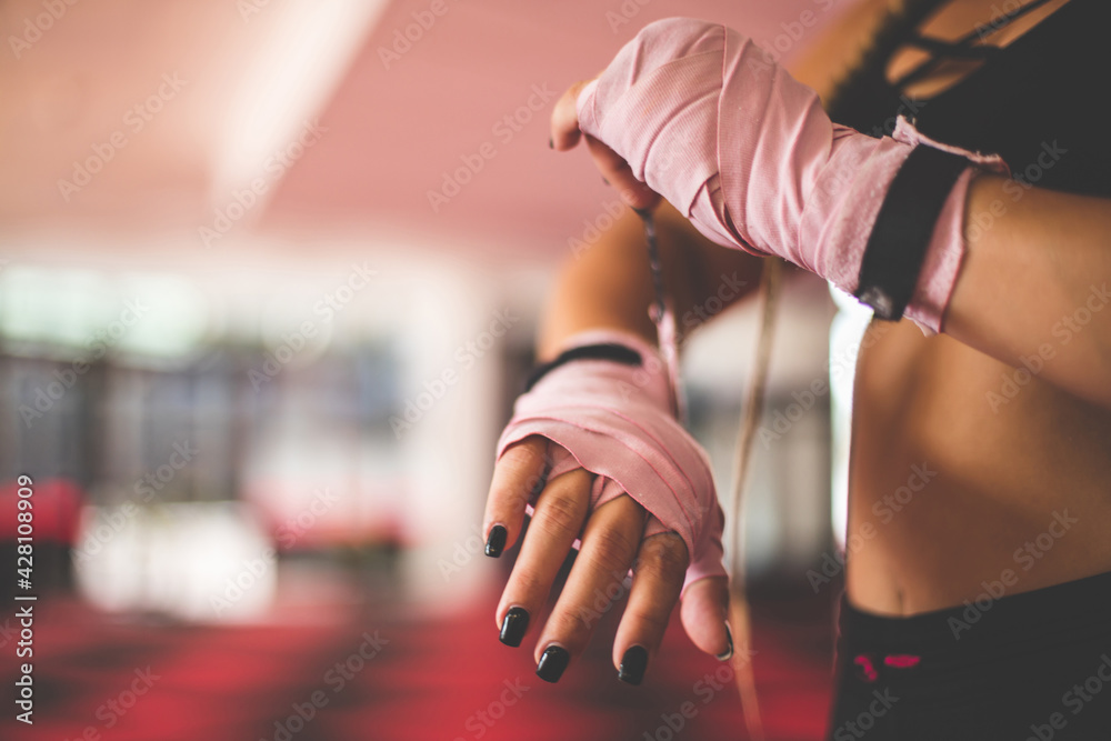Fototapeta premium Woman with boxing gloves. Close up. Focus is on hands.