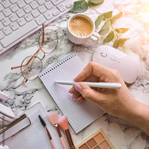 Workplace mockup with notebook, glasses, headphones and make up accessories photo