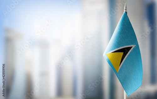 A small flag of Saint Lucia on the background of a blurred background photo