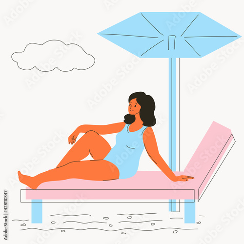 A woman on the beach lies on a chaise longue