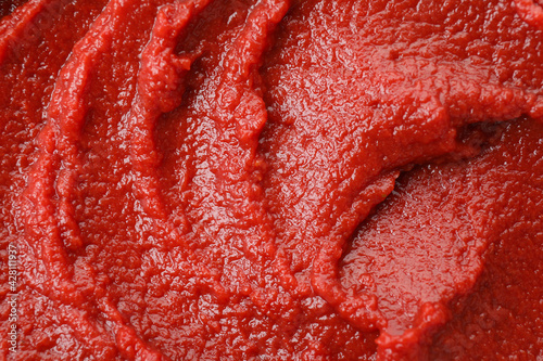 Fotografie Tasty tomato paste on whole background, close up