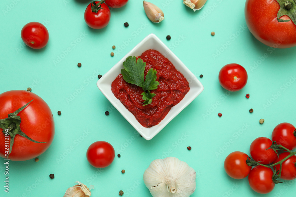 Bowl of tomato paste and ingredients on mint background - obrazy, fototapety, plakaty 