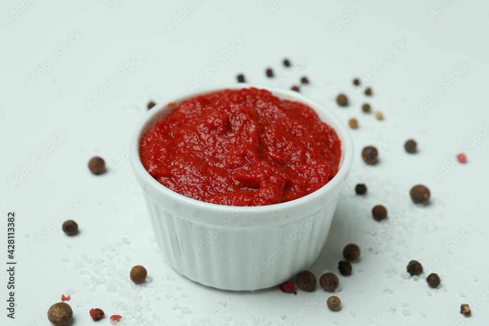 Bowl with tomato paste, pepper and salt on white background Bowl with tomato paste, pepper and salt on white background