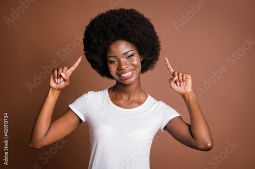 Photo portrait of girl pointing fingers on curly hair hairstyle smiling cheerful isolated on brown color background