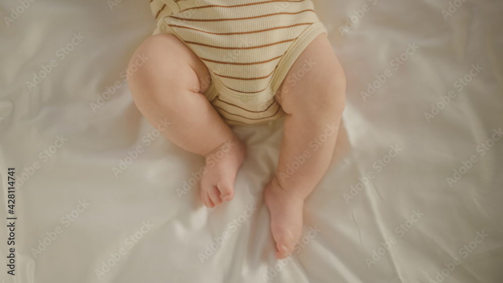 Authentic Close Up Shot of an Adorable Newborn Baby Lying on the Back in Child Crib. Tiny Human Feet of Caucasian Neonate Toddler is in Focus. Concept of Childhood, New Llife and Parenthood. Authentic Close Up Shot of an Adorable Newborn Baby Lying on the Back in Child Crib. Tiny Human Feet of Caucasian Neonate Toddler is in Focus. Concept of Childhood, New Llife and Parenthood.