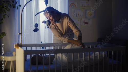 Bild auf Leinwand Authentic Shot of a Mother Soothing and Cuddling a Newborn Baby Boy in Child Crib