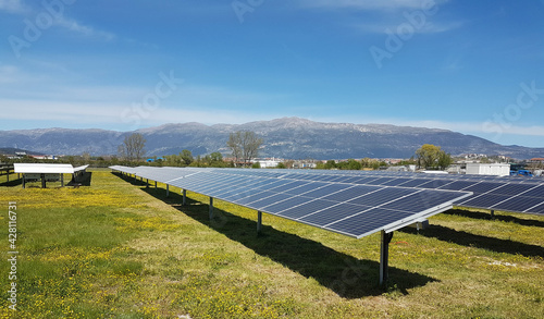 solar panels solar energy in a green meadow and blue bright sky © sea and sun