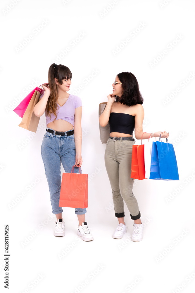 Two girlfriends with shopping bags on white background